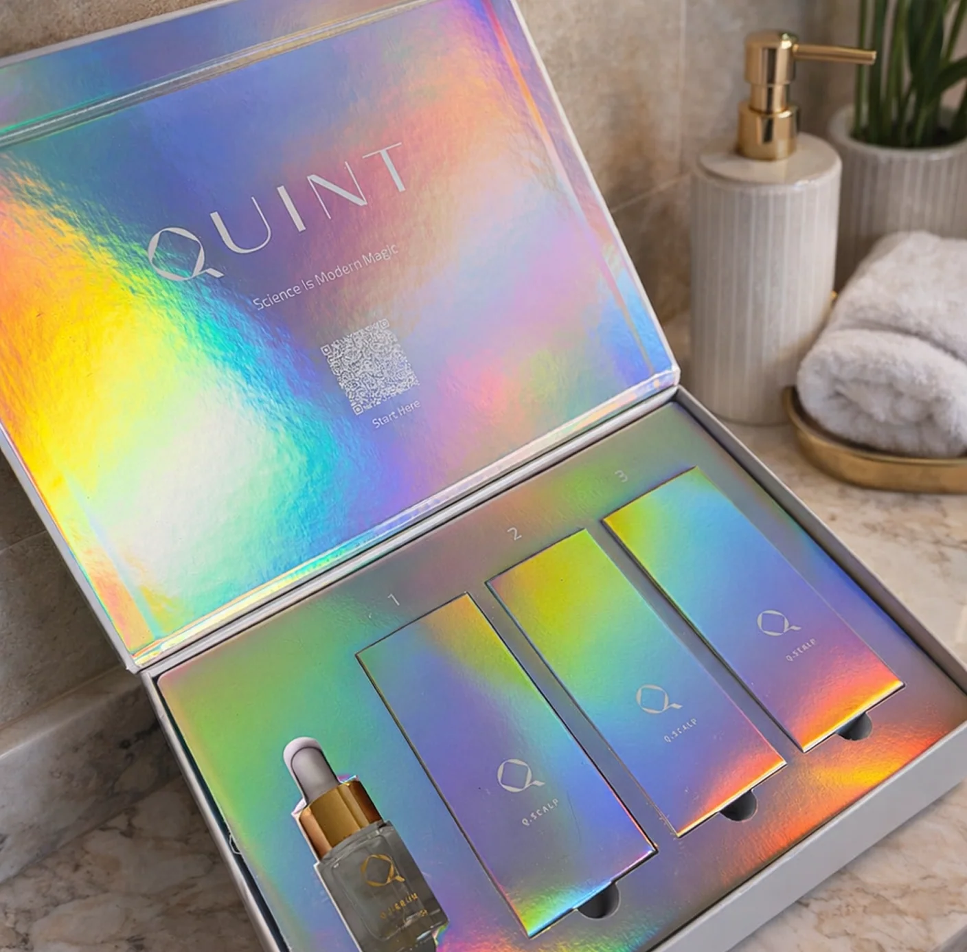 Holographic QUINT Q.Face treatment kit displayed in an open presentation box